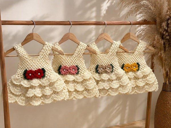Handmade crochet baby dress with scalloped skirt and bow