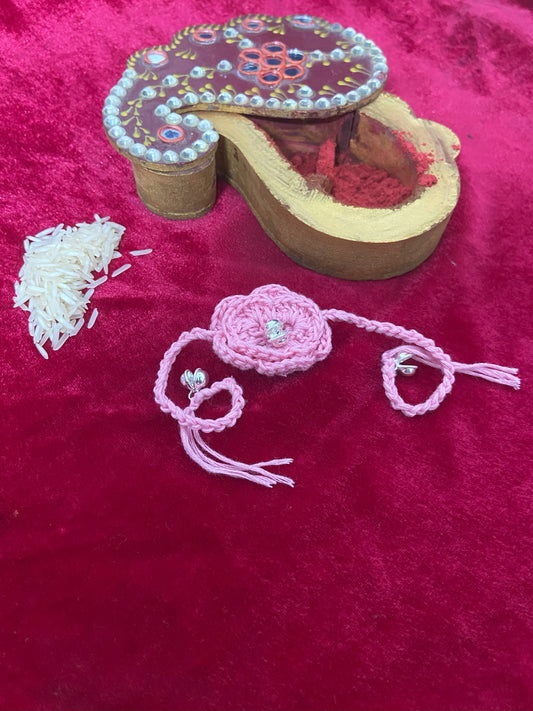 "Blush Bloom Rakhi – Crochet Elegance with Silver Stone & Pink Petals"